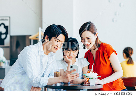 カフェでスマホを見る若い家族 カフェでスマホを見る若い家族 83388859