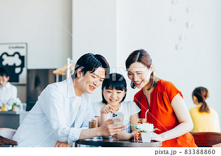 カフェでスマホを見る若い家族 カフェでスマホを見る若い家族 83388860