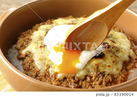 焼きドライカレーにトッピングされている温泉玉子を割って食べる 83390014