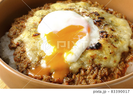 焼きドライカレーにトッピングされている温泉玉子を割って食べる 焼きドライカレーにトッピングされている温泉玉子を割って食べる 83390017