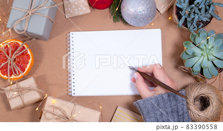 Woman holding calligraphic pen Christmas greeting card template in craft style. Empty paper Woman holding calligraphic pen Christmas greeting card template in craft style. Empty paper 83390558
