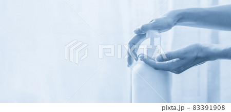 Woman hands pushing pump plastic soap bottle on white background with copy space, blue tone Woman hands pushing pump plastic soap bottle on white background with copy space, blue tone 83391908