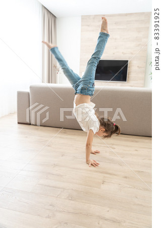 Girl standing upside down on her arms at home 83391925