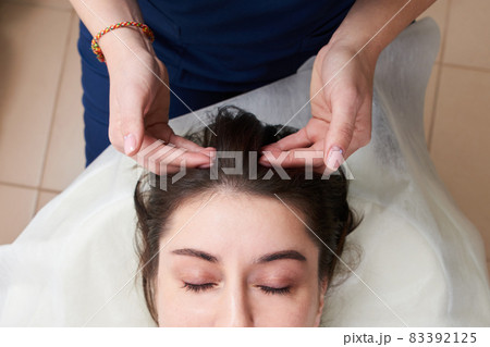 Beautiful Young Woman Getting a Face and head Treatment at Beauty Salon Beautiful Young Woman Getting a Face and head Treatment at Beauty Salon 83392125