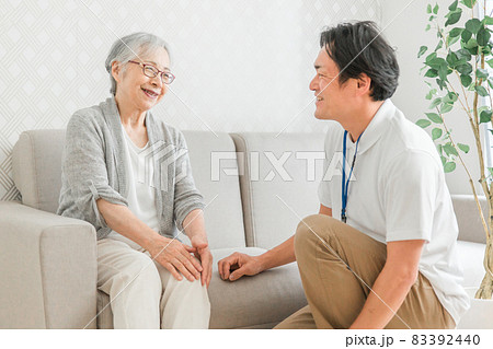 訪問介護する男性と高齢者（笑顔） 83392440