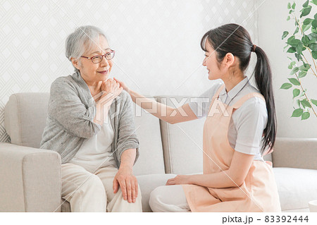 訪問介護する女性と高齢者（肩こり） 83392444