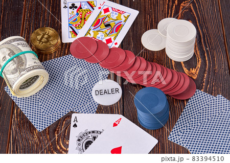 Poker chips with cards and money on wooden desk. Poker chips with cards and money on wooden desk. 83394510