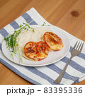 Baked cutlets with tomatoes and cheese with rice on plate 83395336