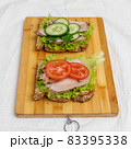 Fresh sandwiches with baked meat and vegetables on cutting board 83395338