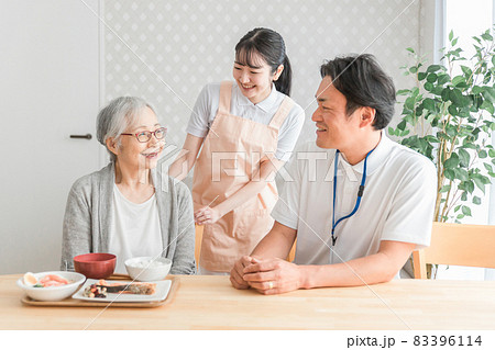 食事する高齢者と男女のスタッフ 83396114
