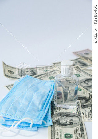 Stack of cash dollars and medical mask sanitizer antiseptic. The concept of medical expensive medicine. Copy space for text. Health Life insurance. vaccination costs. Covid-19 crimes 83396401