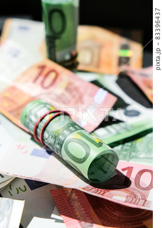 Close up of Euro money roll. Euro banknote set cash money - EU currency. Rolled with rubber euro notes. Banknotes stacked on each other in different positions Close up of Euro money roll. Euro banknote set cash money - EU currency. Rolled with rubber euro notes. Banknotes stacked on each other in different positions 83396437