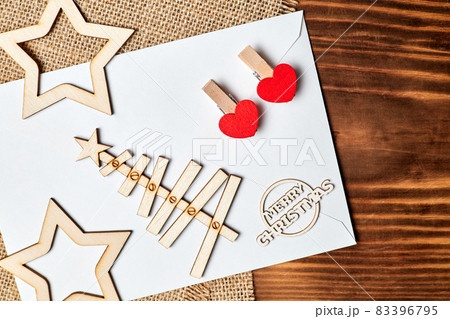 New Year Flatlay on burlap and wooden background made of envelope, Christmas tree, stars and clothespins with hearts. Close-up New Year Flatlay on burlap and wooden background made of envelope, Christmas tree, stars and clothespins with hearts. Close-up 83396795