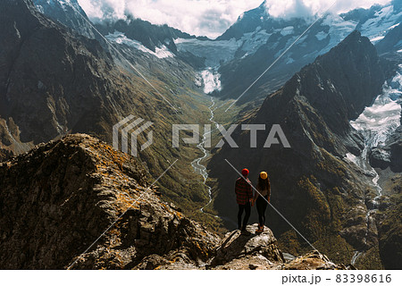 The couple travels through the Caucasus mountains. Man and woman traveling. A walk in the mountains. The couple greets the sunrise in the mountains, rear view. A man and a woman in the mountains The couple travels through the Caucasus mountains. Man and woman traveling. A walk in the mountains. The couple greets the sunrise in the mountains, rear view. A man and a woman in the mountains 83398616