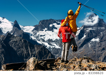 Young couple doing Nordic walking in the mountains, rear view. An active couple is engaged in Hiking. A young couple is engaged in tracking. Trekking and Nordic walking. Hiking. Copy space Young couple doing Nordic walking in the mountains, rear view. An active couple is engaged in Hiking. A young couple is engaged in tracking. Trekking and Nordic walking. Hiking. Copy space 83398620