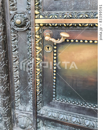 Metal carved historic door with vintage handle and keyhole. Closeup, vertical photo. Metal carved historic door with vintage handle and keyhole. Closeup, vertical photo. 83399591