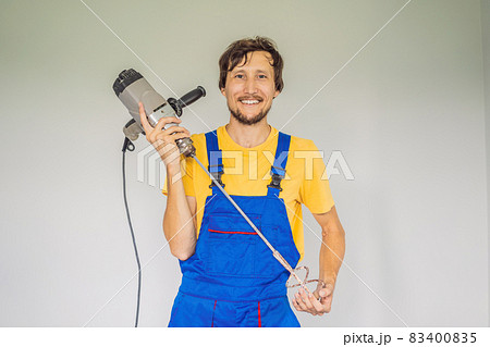 The master at the construction site with a construction mixer 83400835