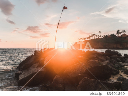 Bright ray of sunlight on a rocky beach by the sea. Vibrant ray of light at sunset.  83401840