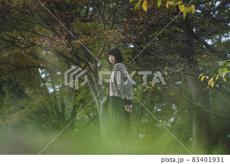 秋の自然公園を散策する女性 83401931