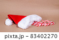 Christmas candy cane and red cap on craft background 83402270