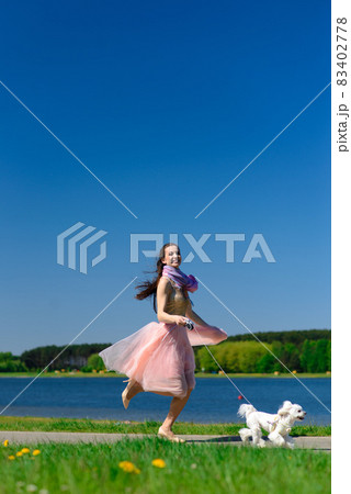 Puppy white dog with it's owner. Concept about friendship, animal and freedom. 83402778