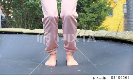young woman is jumping on a babut, a close-up. Legs float in the air after jumping on a trampoline young woman is jumping on a babut, a close-up. Legs float in the air after jumping on a trampoline 83404565