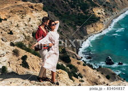 Beautiful couple hugging by the sea. Honeymoon trip. A man and a beautiful woman by the sea. A couple in love is traveling. Vacation by the sea. Couple on a seascape background. Copy space 83404837