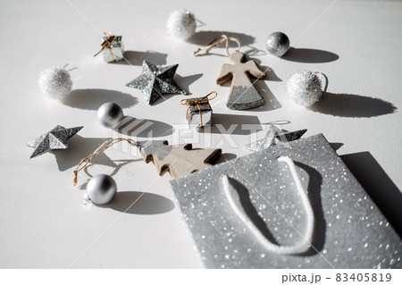 Christmas sale, shopping. Modern pattern, minimal flatlay with silver glitter star and wooden toys. Christmas white silver background with shopping bag and xmas ornaments. Christmas sale, shopping. Modern pattern, minimal flatlay with silver glitter star and wooden toys. Christmas white silver background with shopping bag and xmas ornaments. 83405819