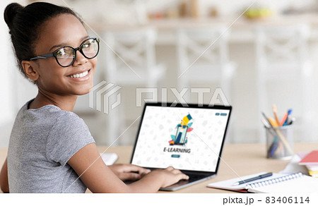 Smiling teenage african american cute girl pupil in glasses study online at home 83406114