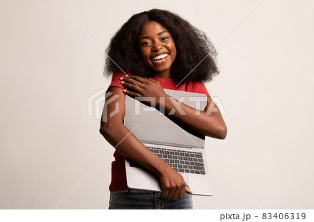 Tech Lover Concept. Cheerful Black Lady Hugging Laptop With Blank Screen Tech Lover Concept. Cheerful Black Lady Hugging Laptop With Blank Screen 83406319