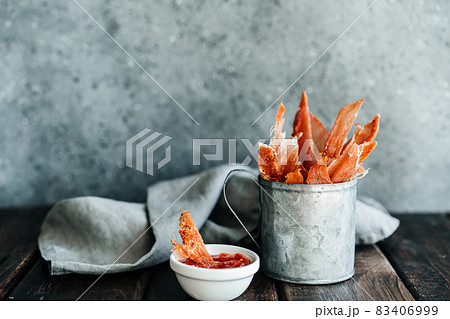 Dried chicken, dried poultry, cut into strips in a metal bucket on a wooden background. Serving a meal in a restaurant Dried chicken, dried poultry, cut into strips in a metal bucket on a wooden background. Serving a meal in a restaurant 83406999