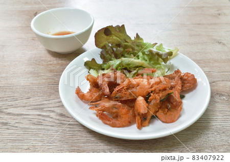 crispy fried salty shrimp with lemon leaf arranging and red oak vegetable on plate dipping sweet sauce cup 83407922
