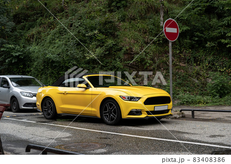 Yellow car is parked at asphalt road in the city 83408386