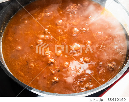 pieces of beef are stewed in red tomato broth pieces of beef are stewed in red tomato broth 83410160