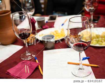 wineglass with tested wine on notes on table 83410167