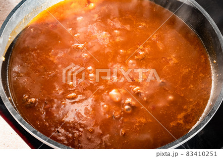 cooking goulash with beef, tomato and paprika 83410251