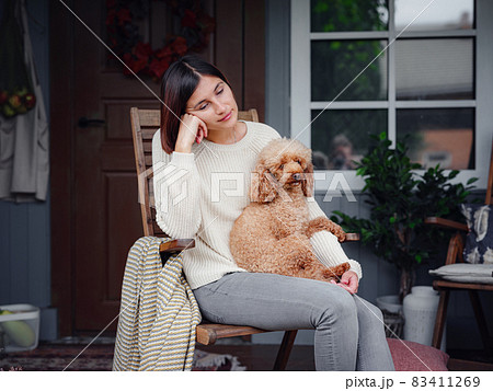Young beautiful woman resting outdoors with cup of coffee with dog. 83411269