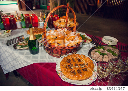 Russian feas. A table set with Russian snacks - pies with stuffing, pickles, meat slicing. 83411367