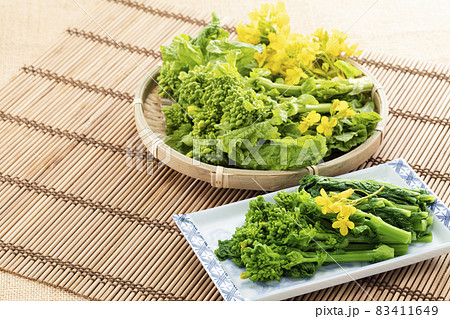 竹マットを敷き、ざるに盛った菜の花と菜の花のお浸し 竹マットを敷き、ざるに盛った菜の花と菜の花のお浸し 83411649
