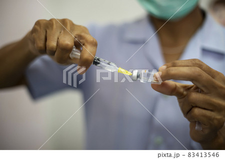 Close-up of doctors, nurses, sucking vaccines from bottles, preparing to vaccinate against and cure from coronavirus, covid-19, flu, infection. Medical concept of vaccination. 83413546