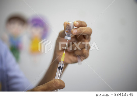 Close-up of doctors, nurses, sucking vaccines from bottles, preparing to vaccinate against and cure from coronavirus, covid-19, flu, infection. Medical concept of vaccination. Close-up of doctors, nurses, sucking vaccines from bottles, preparing to vaccinate against and cure from coronavirus, covid-19, flu, infection. Medical concept of vaccination. 83413549