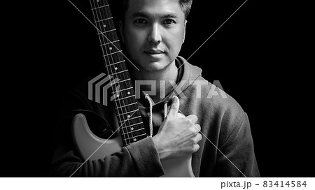 black and white portrait of young asian handsome guitarist, artist, composer, pop rocker star. music concept black and white portrait of young asian handsome guitarist, artist, composer, pop rocker star. music concept 83414584