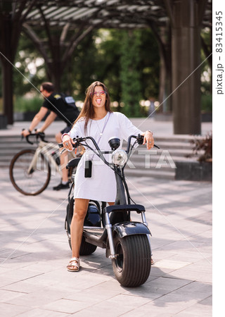 Young beautiful woman teasing and showing tongue at camera in park 83415345