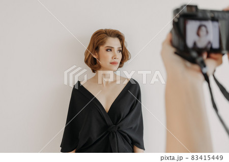 Woman photographer is taking a photo of her woman fashion model. Woman photographer is taking a photo of her woman fashion model. 83415449