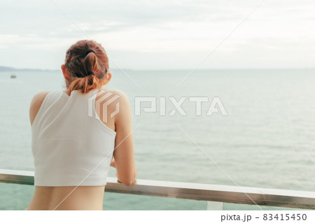 Beautiful woman enjoy looking the sea view from the balcony of the hotel. Beautiful woman enjoy looking the sea view from the balcony of the hotel. 83415450