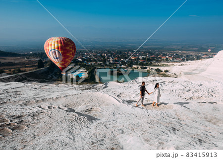 Couple in love among balloons. Couple in love in Pamukkale. Couple in Turkey. Honeymoon trip. A man and a woman are traveling. Flying on balloons. Couple travels the world. Vacation in Turkey Couple in love among balloons. Couple in love in Pamukkale. Couple in Turkey. Honeymoon trip. A man and a woman are traveling. Flying on balloons. Couple travels the world. Vacation in Turkey 83415913