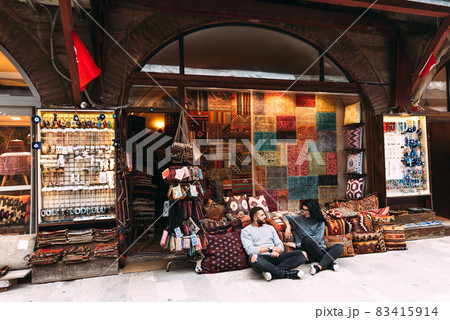 Couple in love at the Bazaar. Couple travels. Man and woman in the store. Souvenirs. Couple in Turkey. Textile store. Tourist shop. Persian shop. Sale of carpets. Iran. Istanbul. Dubai Couple in love at the Bazaar. Couple travels. Man and woman in the store. Souvenirs. Couple in Turkey. Textile store. Tourist shop. Persian shop. Sale of carpets. Iran. Istanbul. Dubai 83415914