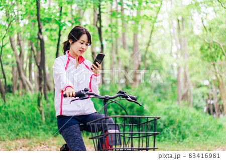 自転車に乗りながらスマホを使う女性 自転車に乗りながらスマホを使う女性 83416981
