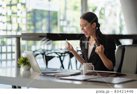 Happy excited successful businesswoman triumphing in office, portrait of asian woman working in modern office Happy excited successful businesswoman triumphing in office, portrait of asian woman working in modern office 83421446