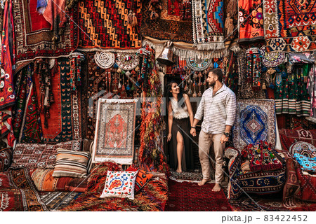 Man and woman in the store. Couple in love in Turkey. Man and woman in the Eastern country. Happy couple travels the world. Persian shop. Tourists in store. Oriental carpet. Istanbul. Follow me 83422452